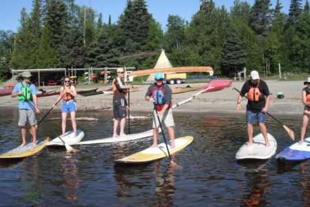 A group going stand up paddling at Naturally Superior Adventures