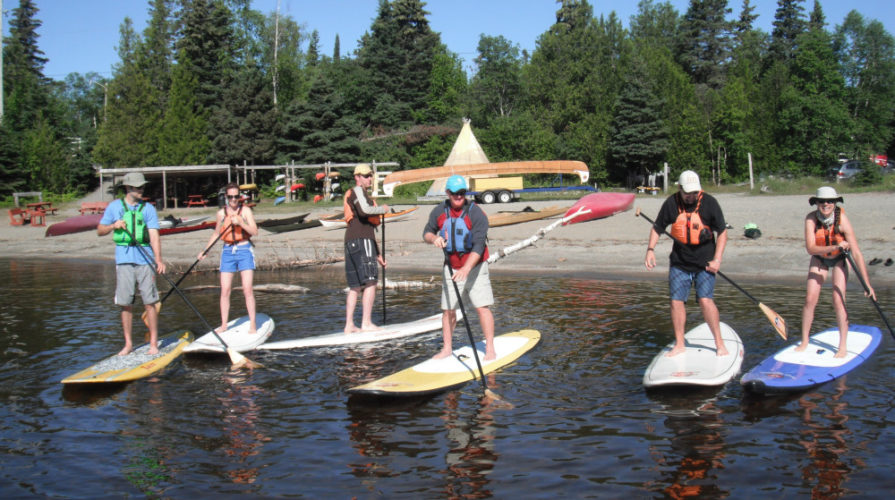 A group going stand up paddling at Naturally Superior Adventures
