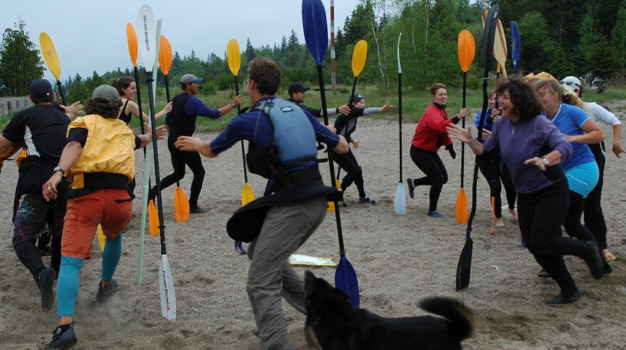 sea kayak students playing a warm-up game on the beach at naturally superior adventure